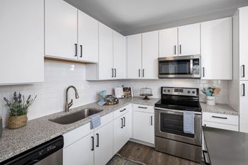 a kitchen with white cabinets and stainless steel appliances